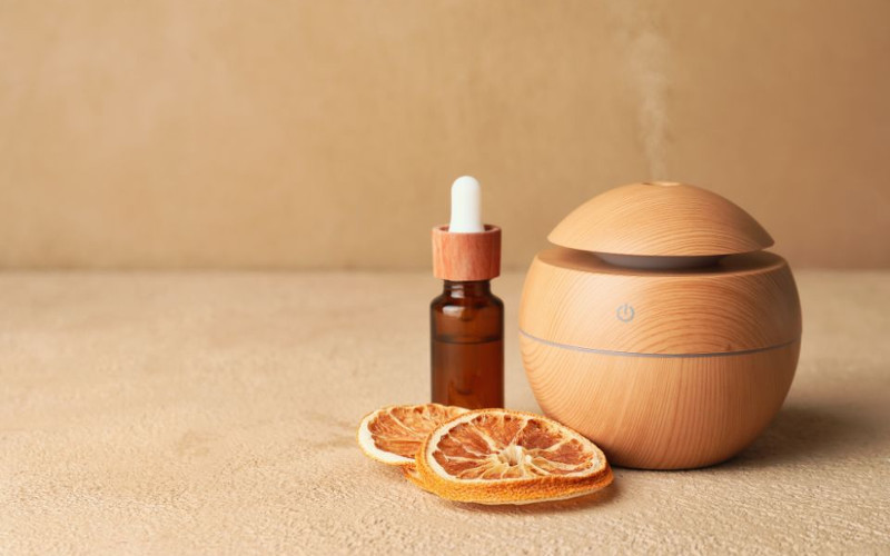 dyfuzor powietrza z butelką olejku i plastrami pomarańczy